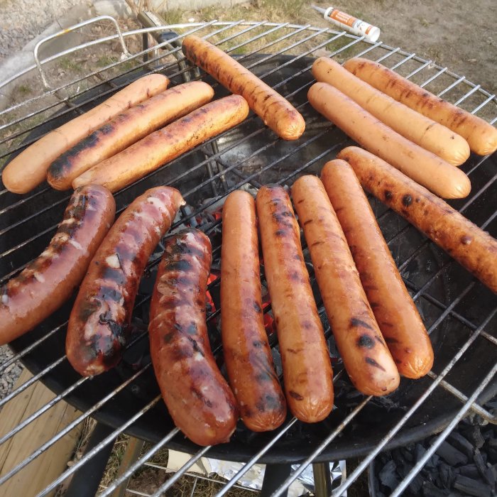 Grillade korvar med varierande grad av grillyta på en kolgrill.