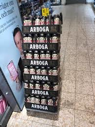 Stapel med öllådor av märket Arboga i en butiksgång.
