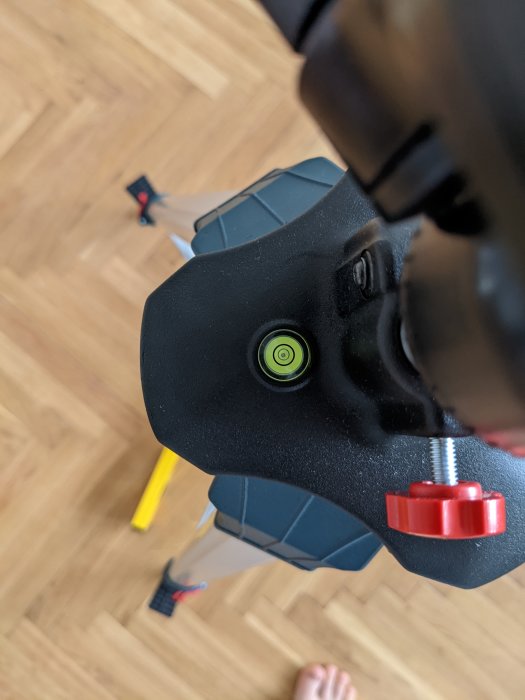 Bosch BT250 professional laserstativ med libell som visar ojämn nivå på ett trägolv.