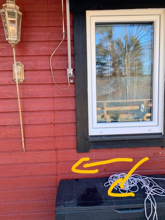 Vatten droppande från takstolen och rinning längs fasaden på ett rött hus.