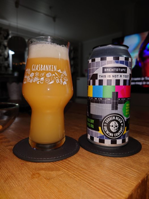 Ett glas med öl märkt "Glasbanken" och en ölburk med texten "BREWTOPIA THIS IS NOT A TEST".
