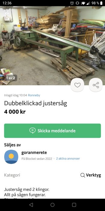 Grön justersåg i en verkstadslokal med virkeshögar och verktyg i bakgrunden.