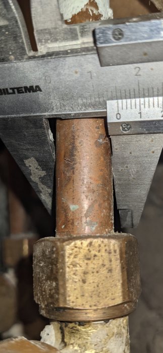 Skjutmått visar 15mm mätning på en rörkoppling med övergångskona.