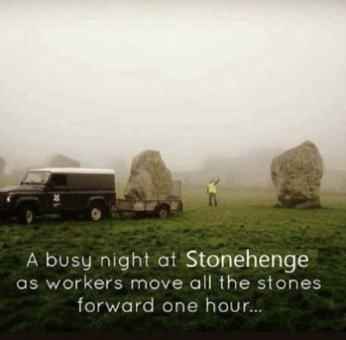 En skämtsam bild som visar Stonehenge i dimma där arbetare låtsas flytta stenblocken framåt en timme.