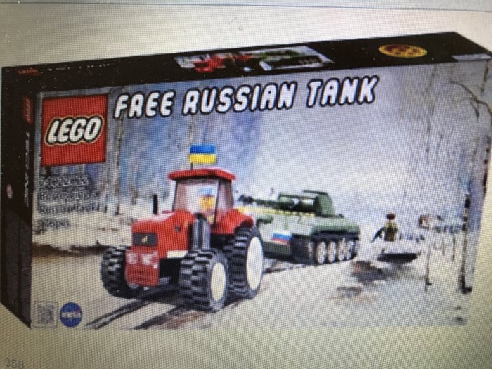 Leksakstraktor drar en stridsvagn förbi en LEGO-låda med texten "Free Russian Tank".