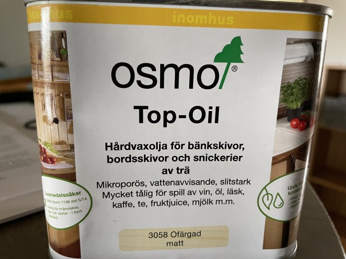 Burk med Osmo Top-Oil hårdvaxolja för träytor, detaljer om användning och egenskaper visas.