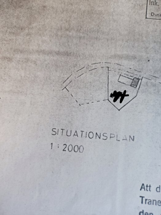 Del av en situationsplan med märkning, skala 1:2000, visar en tomtgräns och en strukturskiss av en byggnad.