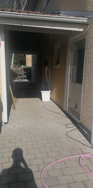 Takutsida av hus med synliga reglar och takpannor, tänkt att bli hall.