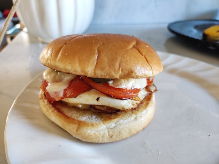 Hamburgare med ägg, bacon och smält ost på en tallrik.
