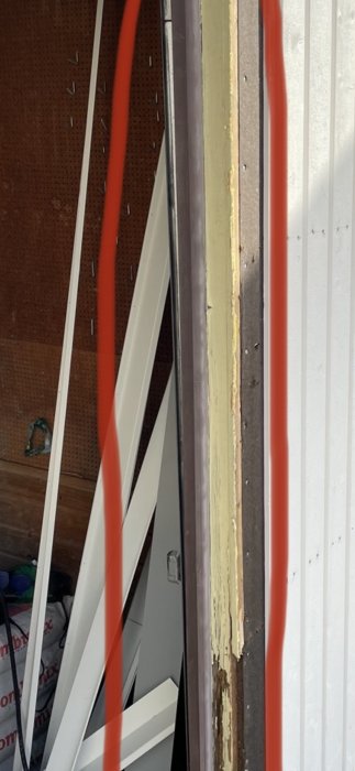 Skadade plastskydd markerade i rött på kanten av en öppen garageport.