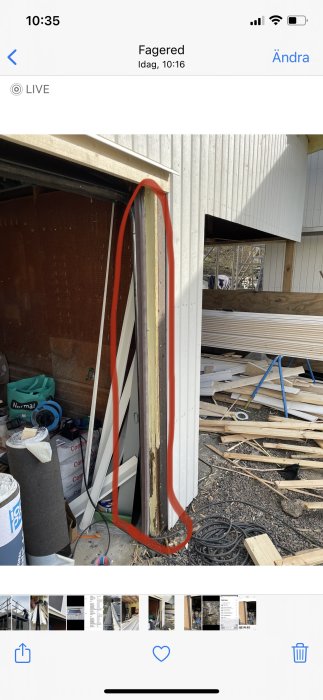 Sliten plastlist vid kanten av en öppen garageport markerad med rött, med byggmaterial i bakgrunden.