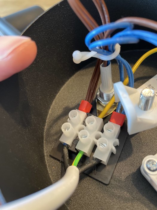 Elektriska kablar anslutna till stickkontakt, omatchande färgkoder, osäker installation.