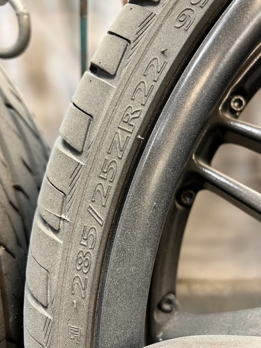 Närbild på ett däck med dimensionerna 265/35 ZR22 monterat på en mörk aluminiumfälg.