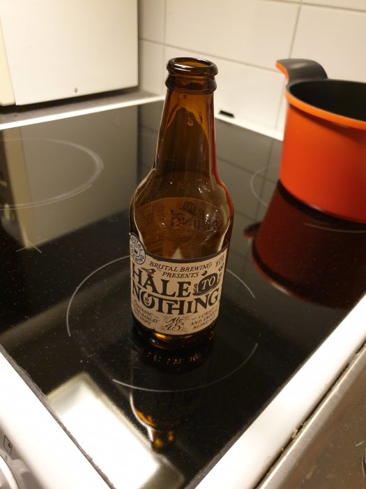 Tom ölflaska märkt "Hale to Nothing" från Brutal Brewing på spishäll.