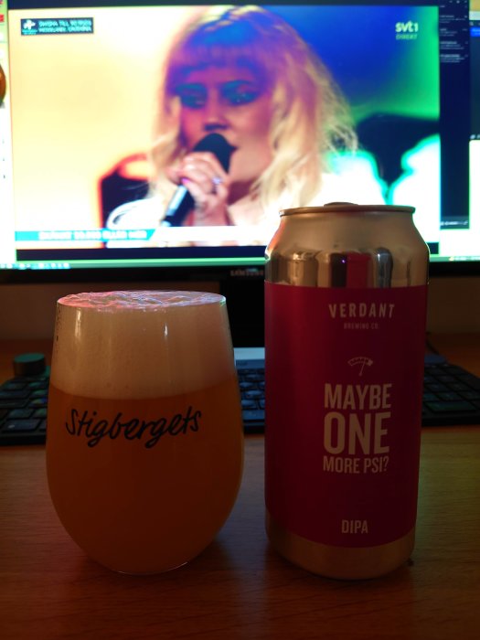 Ölglas märkt Stigbergets och en Verdant burk framför en datorskärm som visar en sångerska på SVT1.