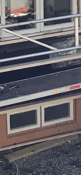 Detaljbild av en regel monterad på en byggkonstruktion med synliga isoleringsmaterial och fönster.