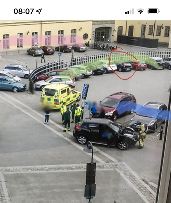 Utsikt över en parkeringsplats med en gul ambulans och parkeringsautomater, inringad bil synlig.