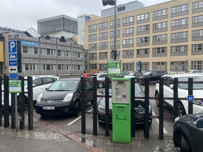 Parkering med elbilsladdstationer, skyltar för P-service och bilar parkerade.