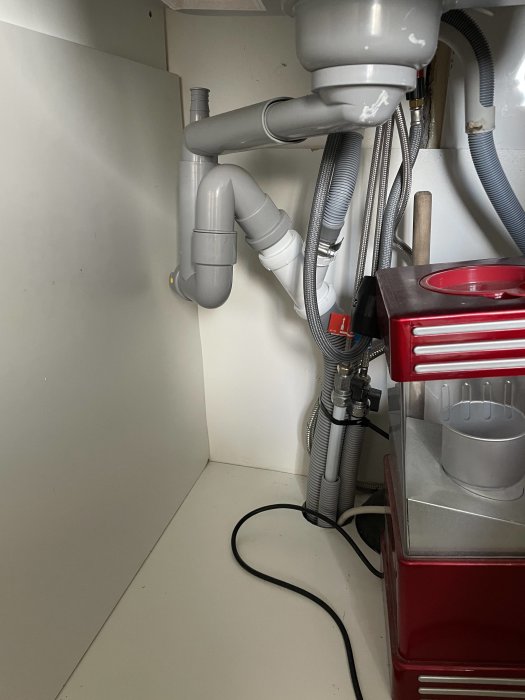 Installation av vakuumluftare under en vask för att förhindra avloppsdoft, med synliga rör och slangar.