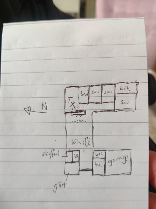 Handritad skiss av husplan med sovrum, kök/vardagsrum, garage och inbyggt tv-rum, sett ovanifrån.