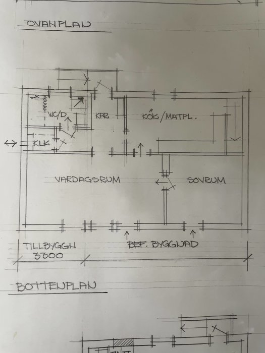 Handritad planritning av ett hus med markerat område för rivning för att öppna mellan kök, vardagsrum och hall.