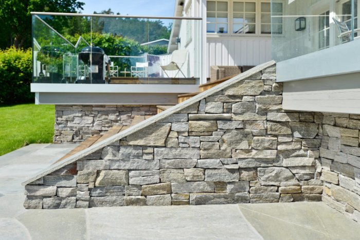Exteriör trappa med stenbeläggning och glasräcke intill en modern villa, inspiration från naturliga färger och material.