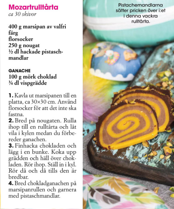 Mozartrulltårta med marzipan och pistaschmandlar, samt påsktema servis och dekoration i bakgrunden.