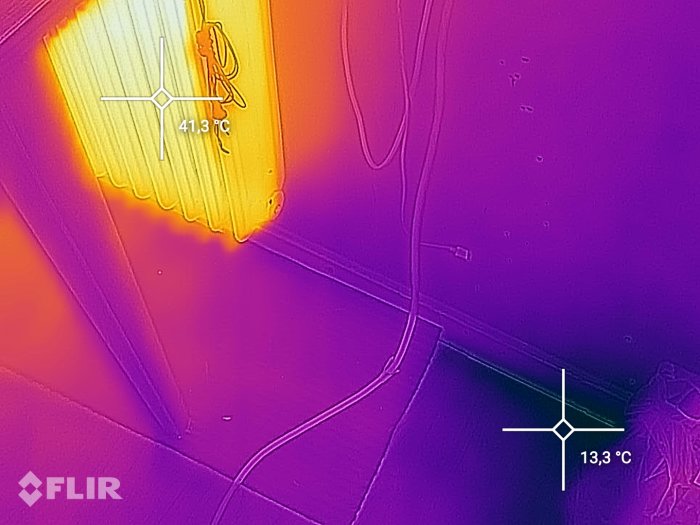 Termisk bild som visar temperaturer, 41,3°C vid en lampa och 13,3°C nära golvet.