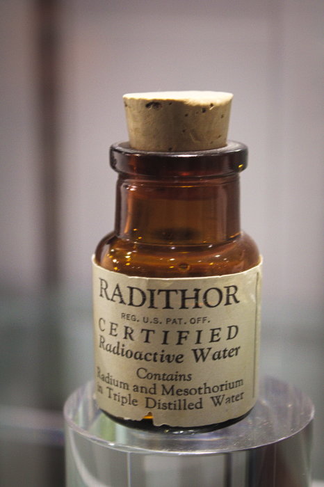 Gammal brun glasflaska med etikett "Radithor" som innehåller radioaktivt vatten och har en kork.