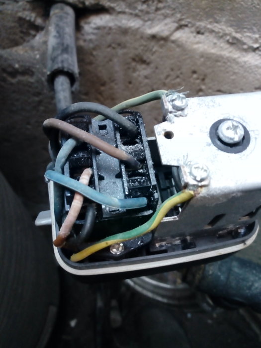 Elanslutningar på en trefaspump med inkommande och utgående kablar i närbild.