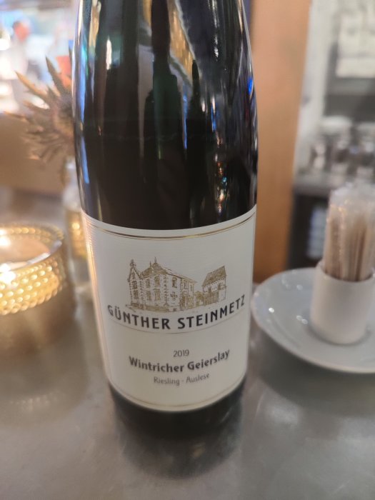 Flaska Günther Steinmetz Wintricher Geierslay Riesling Auslese 2019 på ett bord.