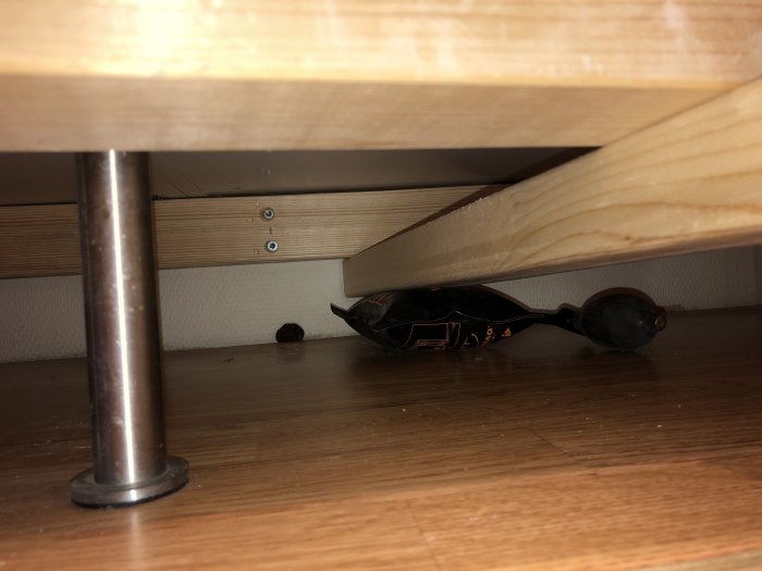 Bortskruvade bordsben och ny regel fäst mot väggen under bordsskiva, arbete pågår.