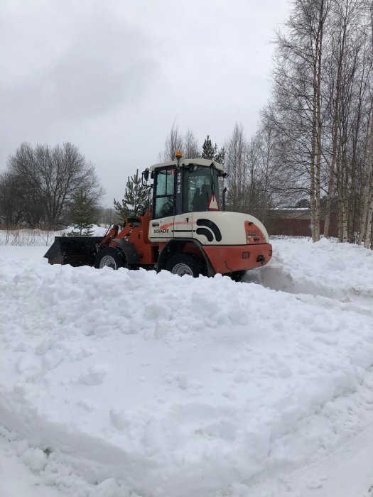 Orange hjullastare i snöig terräng