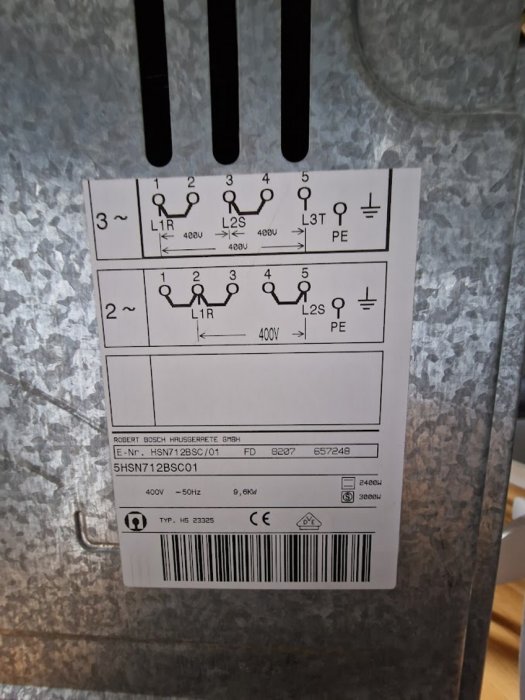 Etikett på en spis visar tekniska specifikationer för 3-fas och 2-fas elanslutning, inklusive 400V och 50Hz märkningar.