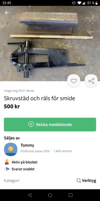 Skruvstäd och räls för smide till salu, ligger på ett smutsigt golv vid sidan av en tumstock.