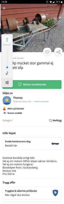 Gammal bandslipmaskin med två slipstenar monterad på en mobil arbetsbänk utomhus.