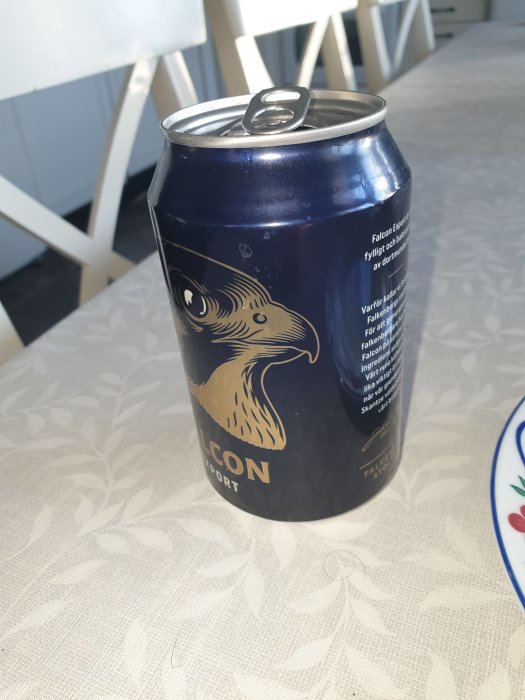 Blå burk av Falcon Export öl med örnlogotyp på ett köksbord.