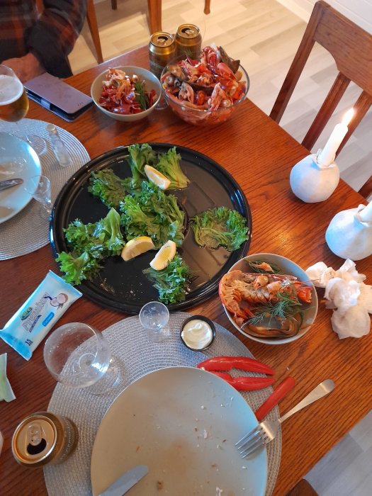 Resterna av en skaldjurstillbricka med tomma skal och såser på ett matbord efter en måltid.