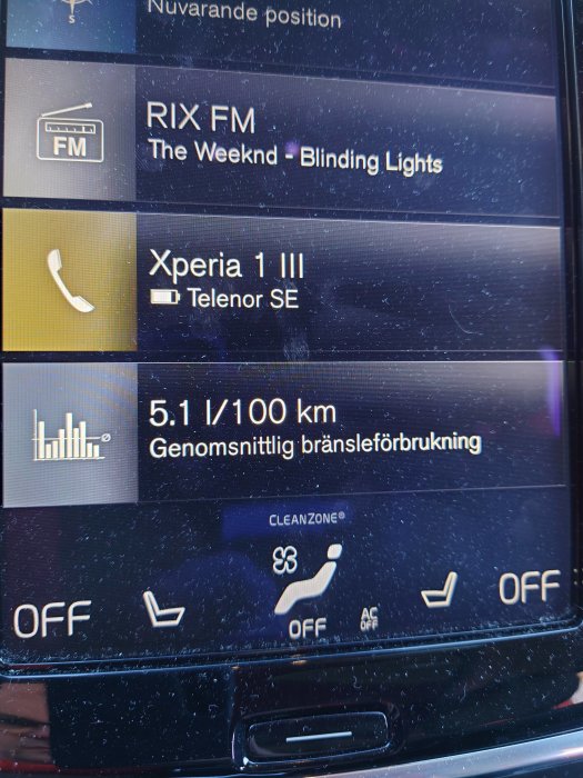 Bilens display visar en genomsnittlig bränsleförbrukning på 5.1 l/100 km med info om musik och kopplad telefon.