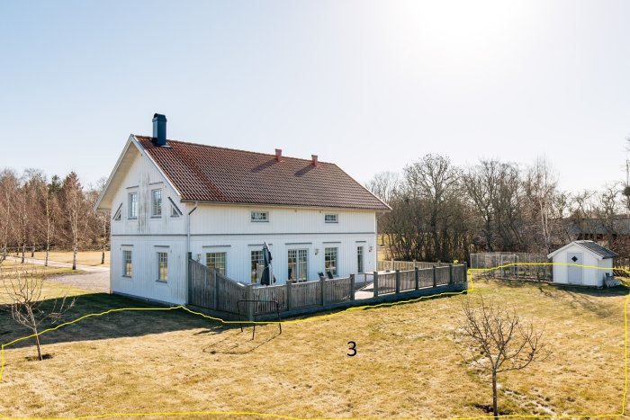 Vit lantgård med markerade sektioner av gräsmattan, med område 3 i förgrunden, omgivet av en häck och träd.