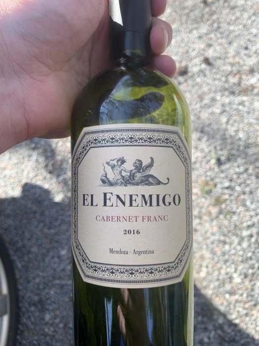 Hand håller en flaska El Enemigo Cabernet Franc 2016 från Mendoza, Argentina.