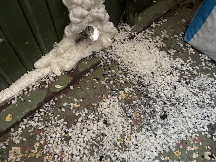 Expanderat byggskum som spridits över en stökig golv yta.