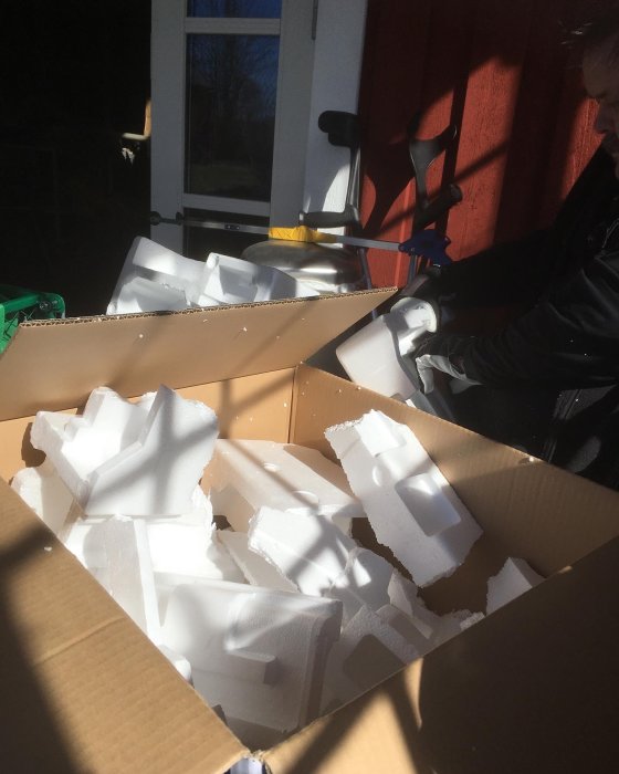 En kartong full med frigolitbitar redo att tas till återvinningen.