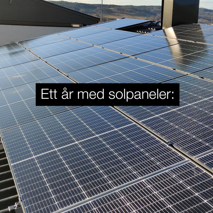 Solpaneler installerade på ett tak med texten "Ett år med solpaneler".