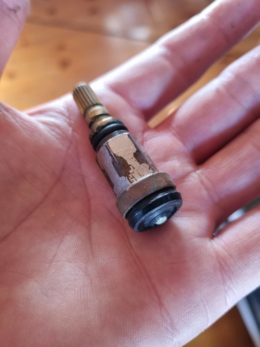 Hand håller en metallpatron med gängor och gummitätningar, inköpt som standardversion på Jula.