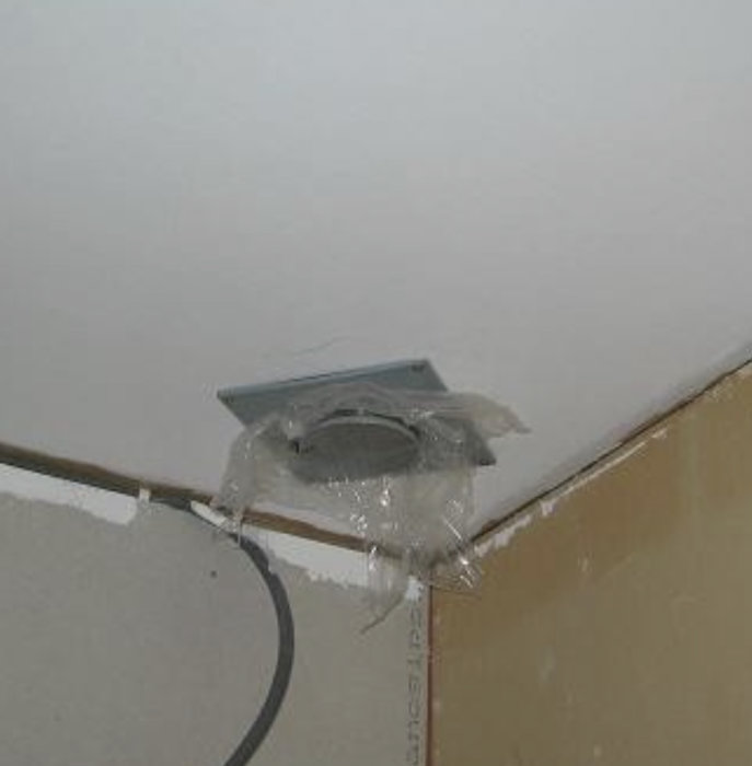 Installation av TFU-beslag i tak med synlig ventilationskanal och elkabel.
