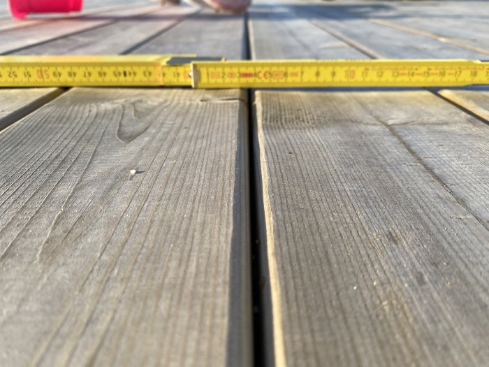 Mätning av trätrall som visar konkav deformation, med vattenansamling på altan.