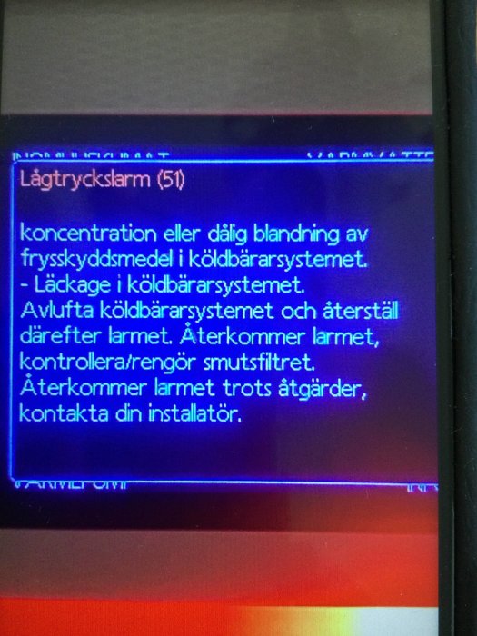 Digital skärm som visar lågtryckslarm och instruktioner för åtgärd.