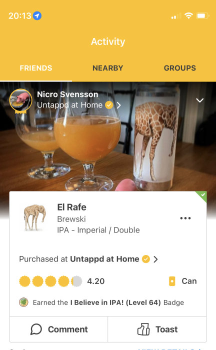 Ölglas med grumlig IPA och ett glas med giraffmönster på ett bord, framför en appskärm.