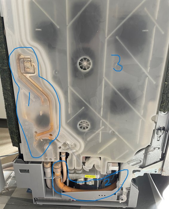 Baksida av diskmaskin med synliga delar och slangen nummer 2 i orange samt område 1 markerat.